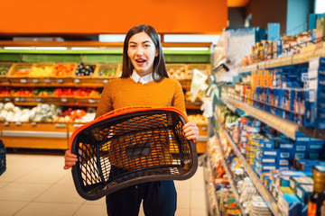 Wall Mural - Woman with empty basket in grocery store