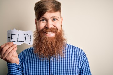 Sticker - Redhead Irish man with beard holding paper with help message over blue background with a happy face standing and smiling with a confident smile showing teeth