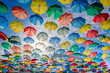 Umbrellas floating in the sky with lots of color
