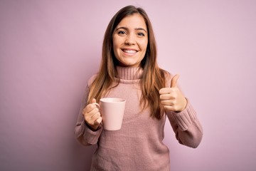 Sticker - Young blonde woman drinking a cup of coffee over pink isolated background happy with big smile doing ok sign, thumb up with fingers, excellent sign