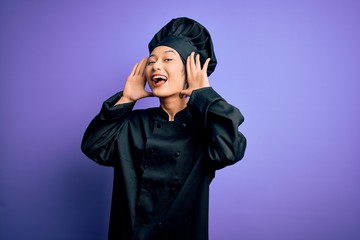 Poster - Young beautiful chinese chef woman wearing cooker uniform and hat over purple background Smiling cheerful playing peek a boo with hands showing face. Surprised and exited