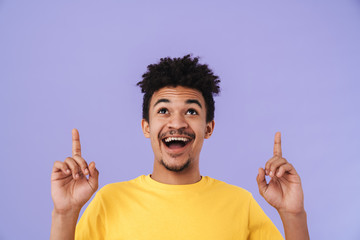 Canvas Print - Photo of african american man smiling and pointing fingers upward