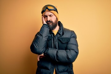 Poster - Handsome skier bald man with beard skiing wearing snow sportswear and ski goggles thinking looking tired and bored with depression problems with crossed arms.