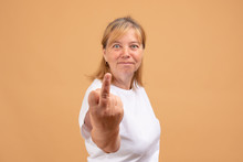 Portrait Of Angry Impolite Rude Woman In Casual Shirt Rejecting Communication, Showing Middle Finger To Express Disrespect And Hate, Vulgar Gesture