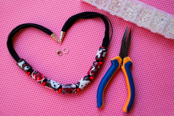 Assembly of red black white necklace. Handmade jewelry design.