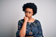 © Krakenimages.com - Young beautiful African American afro woman with curly hair wearing casual floral dress thinking looking tired and bored with depression problems with crossed arms.