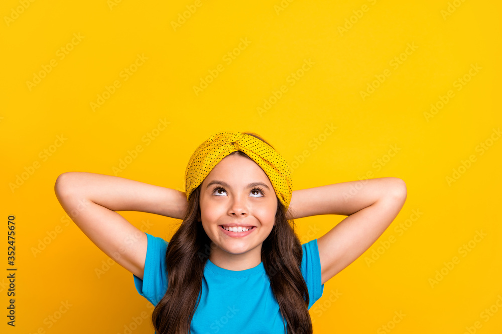 Closeup photo of beautiful little lady model hold arms behind head resting good mood looking up empty space dreamer wear casual blue t-shirt headband isolated yellow color background - obrazy, fototapety, plakaty 