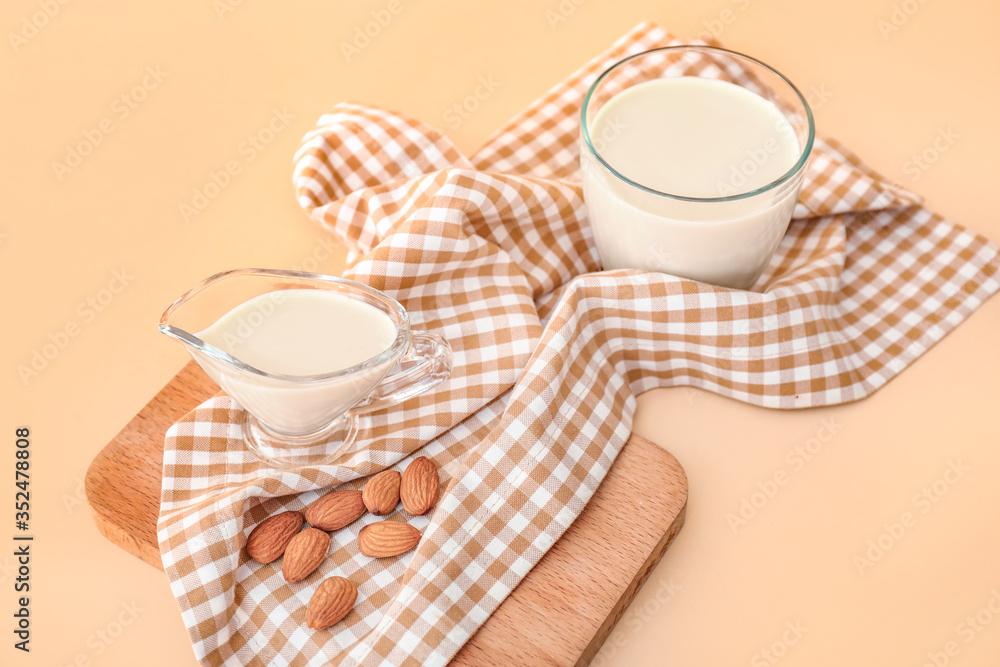 Tasty almond milk on color background