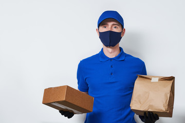 Courier with medical mask on his face holds bag and box.