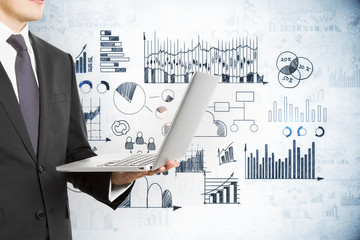 Wall Mural - Businessman with laptop in hand and drawing global marketing plan