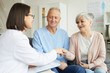 © Seventyfour - Portrait of modern senior couple shaking hands with female doctor and smiling while visiting private clinic