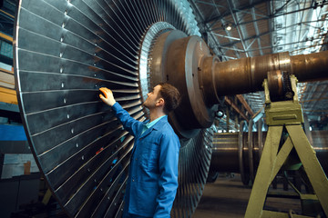 engineer checks turbine impeller vanes, factory