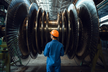 worker checks turbine impeller vanes on factory