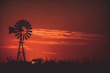 Silhouette American-style Windmill On Field Against Red Sky During Sunset