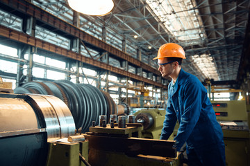 Poster - Male worker checks turning lathe on plant