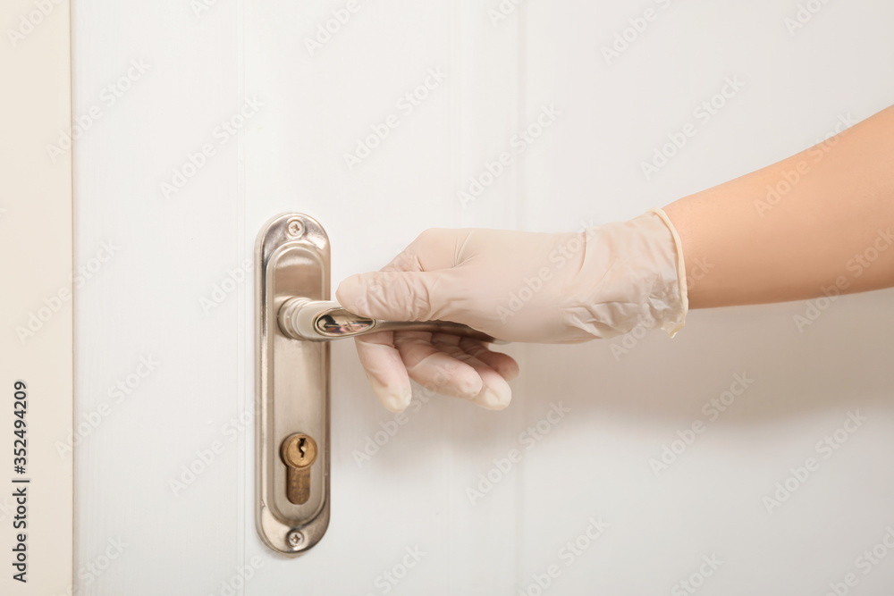 Woman in protective gloves opening door, closeup
