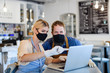 © Halfpoint - Coffee shop owners with face masks, lockdown, quarantine, coronavirus, back to normal concept.