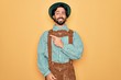 © Krakenimages.com - Young handsome man wearing tratidional german octoberfest custome for Germany festival cheerful with a smile on face pointing with hand and finger up to the side with happy and natural expression