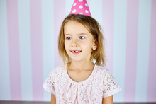 Little Beautiful Girl Wearing Birthday Pink Cap On Pink White Stripe Background.