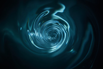 smooth and beautiuful blue vortex. whirlpool, water swirl, top view. high speed liquid photography.