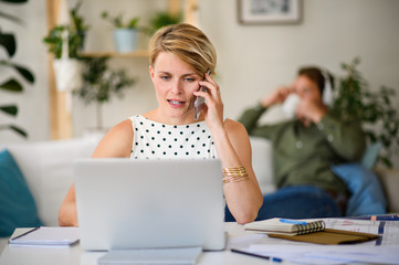 Poster - Cheerful young businesswoman with telephone indoors in home office, working.