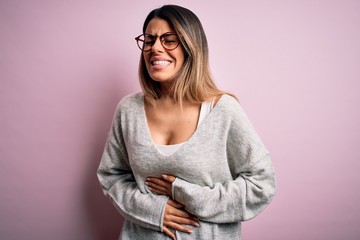 Sticker - Young beautiful brunette woman wearing casual sweater and glasses over pink background with hand on stomach because nausea, painful disease feeling unwell. Ache concept.