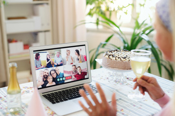 Wall Mural - Senior woman with laptop indoors at home, celebrating distance birthday.