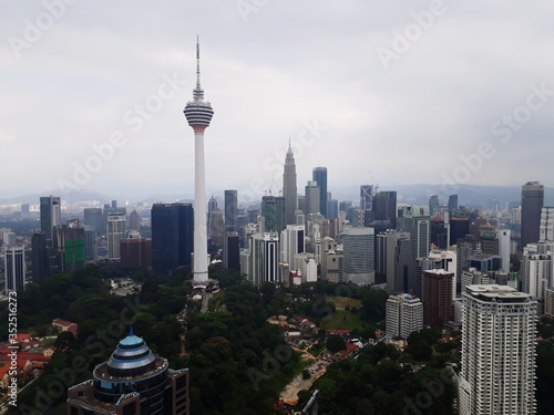 Plakat Kuala Lumpur Tower wśród nowoczesnych budynków w mieście