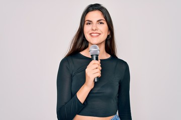 Canvas Print - Young beautiful singer performer girl singing using music microphone over isolated background with a happy face standing and smiling with a confident smile showing teeth