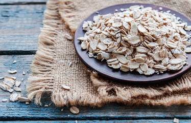 Wall Mural - Gray oatmeal on a background of blue boards near the burlap. The concept of a healthy diet.