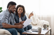 © Prostock-studio - Young african american spouses checking documentation at home, reading insurance agreement