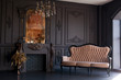 Black room interior with a vintage sofa, chandelier, mirror and fireplace