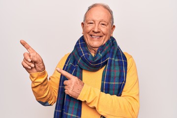 Poster - Senior handsome grey-haired man wearing casual scarf over isolated white background smiling and looking at the camera pointing with two hands and fingers to the side.