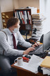 © Yakobchuk Olena - Responsible adult man working on laptop in office wearing hygienic mask