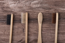 Top Above Overhead Flat Lay Flatlay Close Up Macro Photo Of Four Toothbrushes Of Black White Beige And Brown Colors Isolated On Rustic Wooden Background