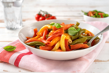 Wall Mural - Close up of vivid and colored Italian penne in a white plate