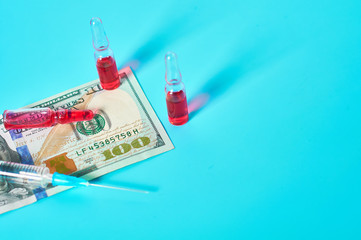 Wall Mural - Banknote of 100 usd, vaccine and syringe on green background. Corruption in medicine. Purchasing medications in pharmacy. Drugs donations. Payment for treatment. Health сare concept