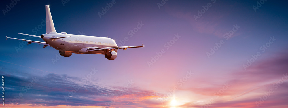 Commercial airplane jetliner flying above dramatic clouds in beautiful light. Travel concept. - obrazy, fototapety, plakaty 