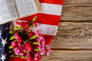 Wall Mural - Open reading Bible on a closeup of Carnation of cut flowers in the American flag