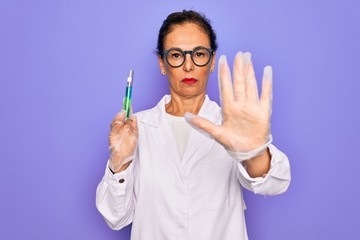 Poster - Middle age senior scientist woman wearing laboratory coat holding research test tube with open hand doing stop sign with serious and confident expression, defense gesture