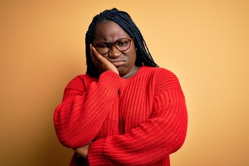 Poster - African american plus size woman with braids wearing casual sweater over yellow background thinking looking tired and bored with depression problems with crossed arms.