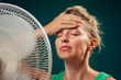 © Aleksej - A portrait of woman in front of fan suffering from heat. Close up. Hot weather concept