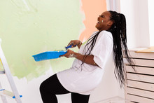 Happy Smiling African American Woman Painting Interior Wall Of New House. Redecoration, Renovation, Apartment Repair And Refreshment Concept.