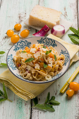 Wall Mural - tagliatelle pasta with yellow fresh tomatoes sheep cheese and mint leaves