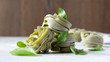 Uncooked spinach pasta tagliatelle (agli spinaci) with fresh spinach leaves, healthy whole wheat pasta nests