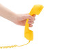 © Nikolay - Yellow handset in woman hand isolated on white.