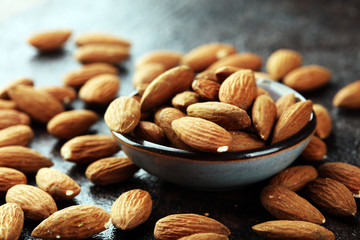 Canvas Print - Almonds on a rustic background and almond in bowl.