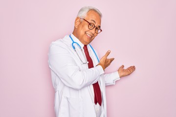 Sticker - Middle age senior grey-haired doctor man wearing stethoscope and professional medical coat Inviting to enter smiling natural with open hand