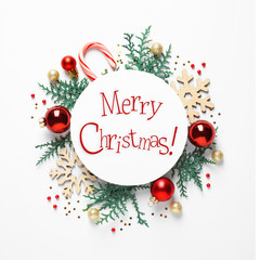 Flat lay composition with text MERRY CHRISTMAS and festive decor on white background