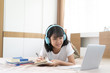 © kromkrathog - Asian girl studying homework online lesson, Social distance online education at home idea concept